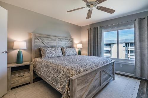 a bedroom with a bed with a ceiling fan and a window at NEW LISTING! Ocean and Pool Views on Harbor Island - Short Walk to Pool and Beach in Harbor Island