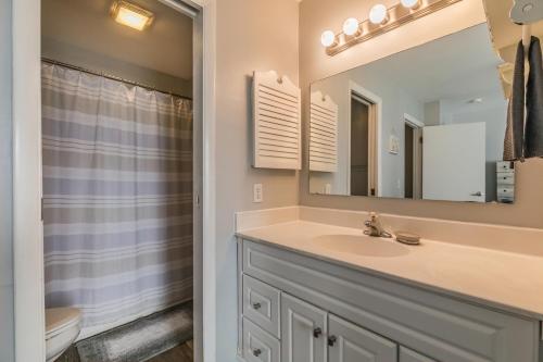 a bathroom with a sink and a toilet and a mirror at NEW LISTING! Ocean and Pool Views on Harbor Island - Short Walk to Pool and Beach in Harbor Island