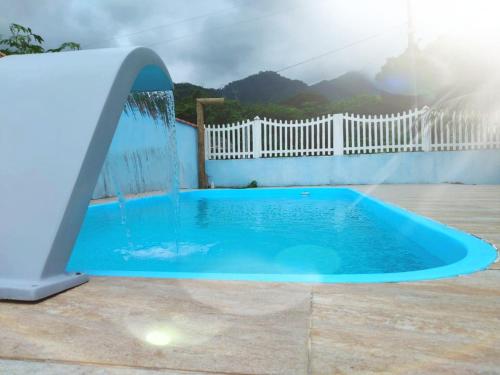 uma piscina azul com um escorrega num quintal em Onde a paz prevalece em Angra dos Reis