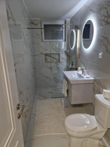 een witte badkamer met een toilet en een wastafel bij Stan na dan Jelica Stanivuković in Šid