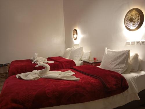 two beds in a hotel room with towels on them at Riad Papadou in Marrakesh