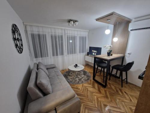 een woonkamer met een bank en een tafel bij Stan na dan Jelica Stanivuković in Šid