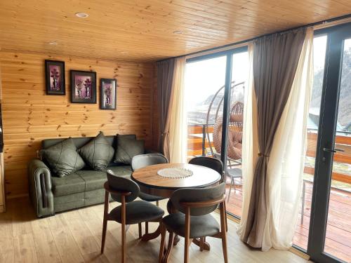 - un salon avec un canapé et une table dans l'établissement Cozy Home Kazbegi, à Kazbegi