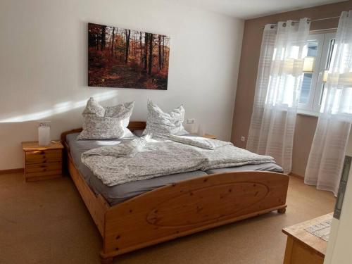 1 dormitorio con cama de madera y almohadas en Ferienwohnung Albliebe en Meßstetten