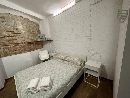 a bedroom with a bed and a white brick wall at Rosario Apartament 4Px2b Wifi in Valencia