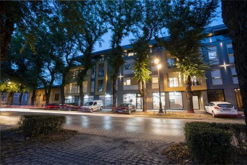 a street with cars parked in front of a building at DONNER LUXURY APARTMAN in Subotica