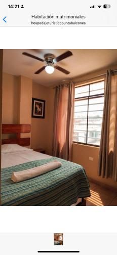 een slaapkamer met een bed, een plafondventilator en een raam bij Hospedaje Punta Balcones in Negritos
