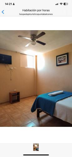 een slaapkamer met een bed en een plafondventilator bij Hospedaje Punta Balcones in Negritos