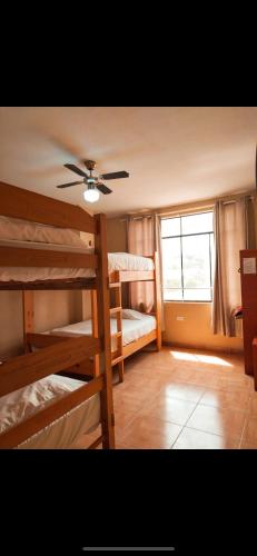 Zimmer mit 2 Etagenbetten und einem Deckenventilator. in der Unterkunft Hospedaje Punta Balcones in Negritos