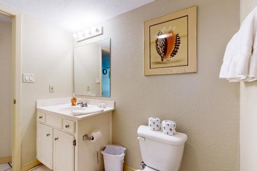 uma casa de banho com um WC, um lavatório e um espelho. em Saida Tower III #3116 em South Padre Island