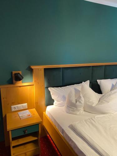 1 dormitorio con 1 cama con pared azul en Beim Has’n en Rimsting