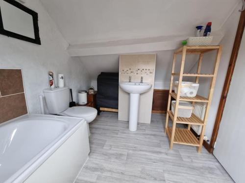 a bathroom with a tub and a toilet and a sink at Cosy Cottage in Edern, Morfa Nefyn, Golf, Near Ty Coch in Ederyn