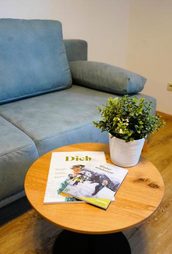 a coffee table with a magazine and a couch at Bucheggerhof in Schladming