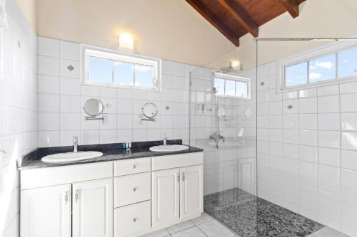 een witte badkamer met 2 wastafels en een douche bij Moko 119 in Noord