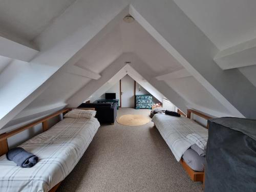 a room with three beds in a attic at Yr Hen Efail in Ederyn