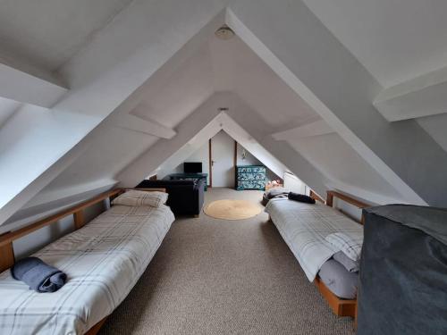 a room with three beds in a attic at Cosy Cottage in Edern, Morfa Nefyn, Golf, Near Ty Coch in Ederyn