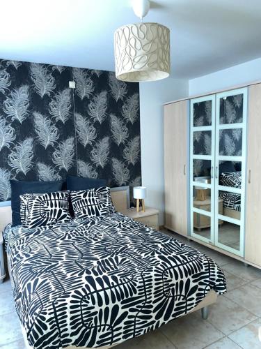 a bedroom with a bed with a black and white comforter at Appartement de charme in Fleurus