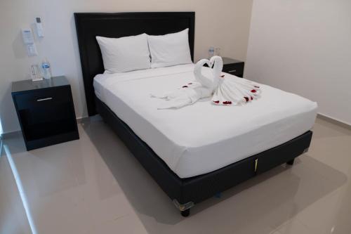 a bedroom with a bed with a wedding dress on it at Hotel & Suites Yuca Ville Siglo XXI in Mérida