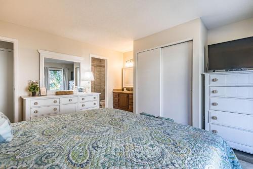 a bedroom with a large bed and a dresser at First Floor Condo - Walking distance to beach and pools! in Harbor Island