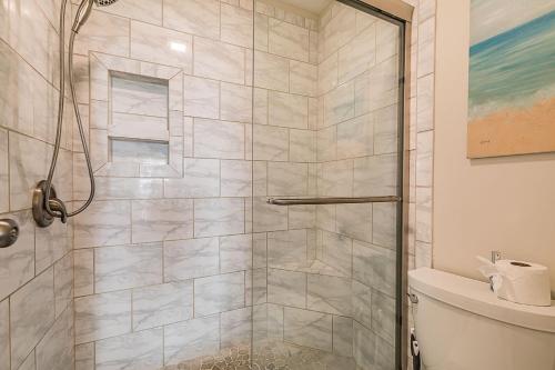 a shower with a glass door in a bathroom at First Floor Condo - Walking distance to beach and pools! in Harbor Island