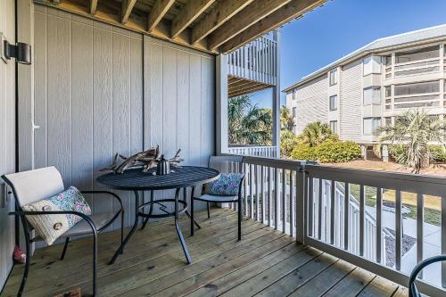 a patio with a table and chairs on a balcony at First Floor Condo - Walking distance to beach and pools! in Harbor Island