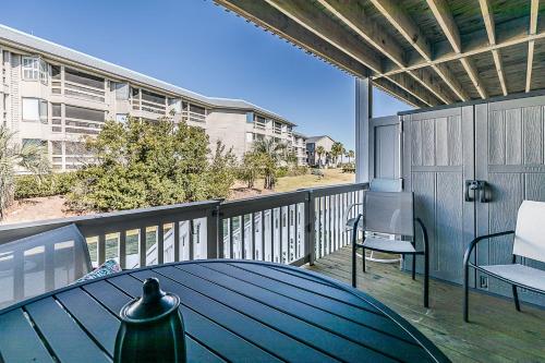 a deck with a table and chairs on a balcony at First Floor Condo - Walking distance to beach and pools! in Harbor Island