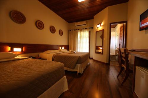 a hotel room with two beds and a window at Ecoporan Hotel Charme Spa & Eventos in Itacaré