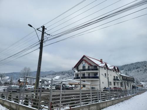 um grande edifício branco sobre uma ponte na neve em Soimii Bucovinei Residence em Vatra Moldoviţei