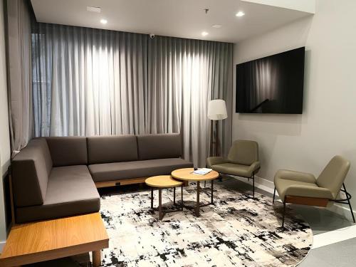 a living room with a couch and a table and chairs at Transamerica Executive Faria Lima in Sao Paulo