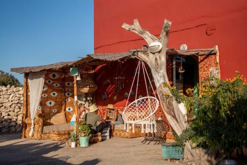 a porch of a house with a tree branch at Ayour Hostel in Sidi Kaouki