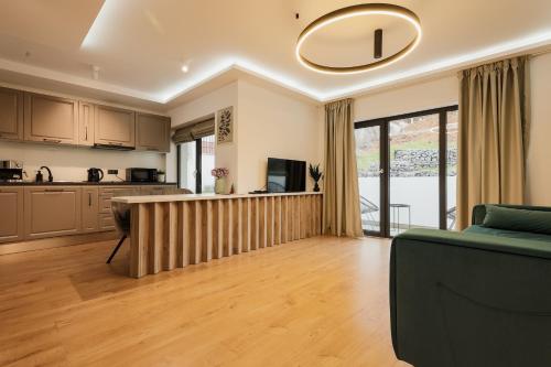 een keuken en een woonkamer met een bank en een tafel bij Aparthotel Nest Inn Meteor in Cluj-Napoca