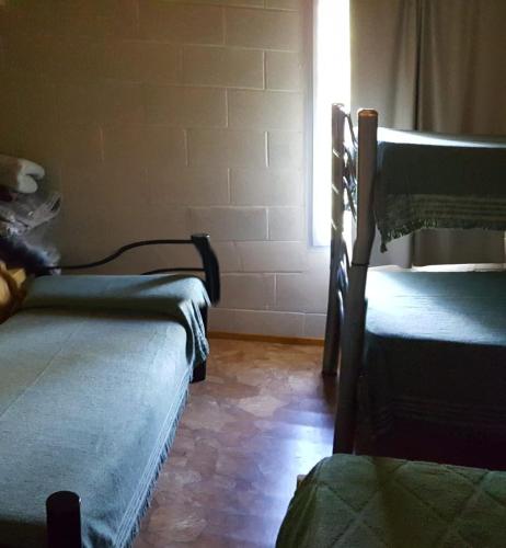 2 camas en una habitación con ventana en Calamuchita Lodges en Villa Rumipal