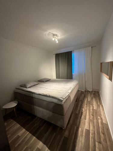 Un dormitorio con una cama grande y una ventana en Cozy and modern apartment with lakeside view, en Rovaniemi