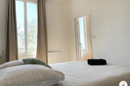 une chambre avec un lit et une grande fenêtre dans l'établissement L'Armateur - Confort - Standing Marché, au Havre