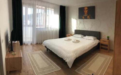 um quarto com uma cama grande e lençóis brancos em STEFANIA em Piatra Neamţ