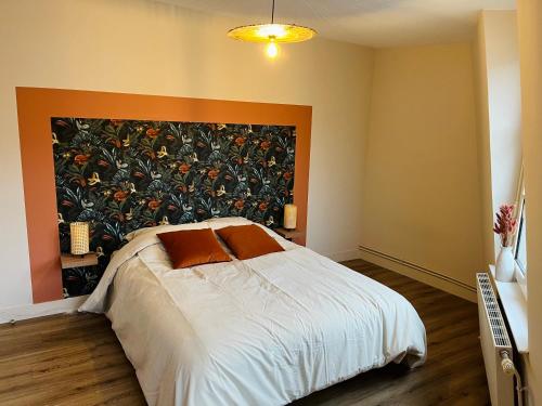 a bedroom with a bed with a large painting on the wall at Appartement centre ville Caen Vaugueux in Caen