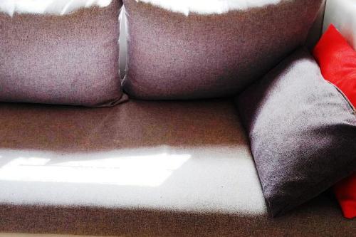 a group of pillows sitting on top of a couch at Bel appartement calme est bien équipé in Meknès