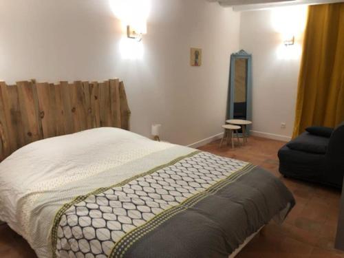 Amné-en-Champagne的住宿－Gite de charme avec piscine intérieure，一间卧室配有一张床、一把椅子和一张沙发