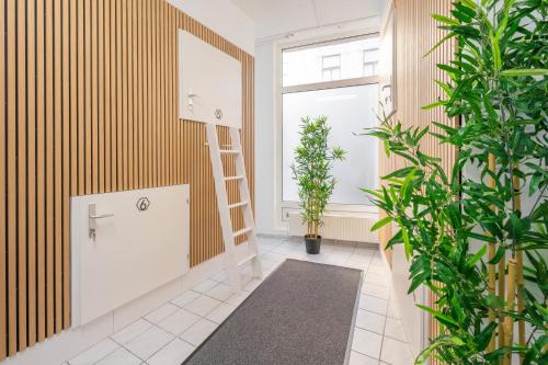 baño con plantas verdes y espejo en Robin Wood Apartment en Viena