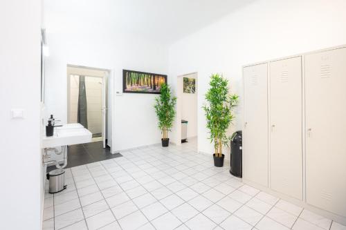 a bathroom with a sink and a white tiled floor at Robin Wood Apartment in Vienna