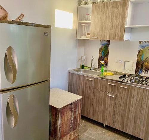 a kitchen with a stainless steel refrigerator and wooden cabinets at Sunset View, Taganga in Taganga