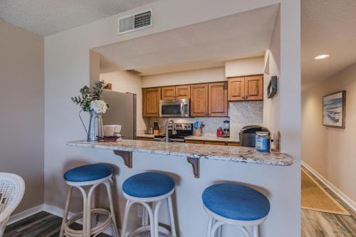 a kitchen with two blue stools at a counter at Crow's Nest On Harbor Island - One Bedroom on Third Floor in Harbor Island