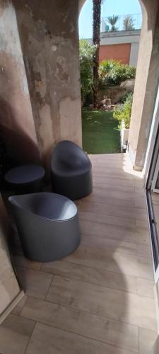 two black stools sitting on a wooden porch with at Appartamento vicino al lago in Brissago