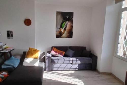 a living room with a couch and a picture on the wall at Appartamento vicino al lago in Brissago