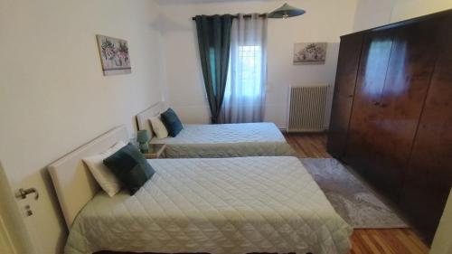 a bedroom with two beds and a door with a window at Kastraki House with a view in Kastrákion