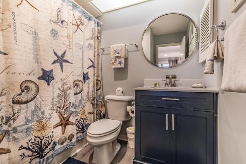 a bathroom with a toilet and a sink and a mirror at Direct Ocean View! M Building Pool and Ocean Views in Harbor Island
