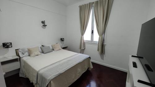 een witte slaapkamer met een bed en een raam bij Palermo Soho, Oh! Mi lugar favorito in Buenos Aires