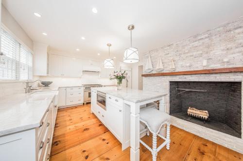a kitchen with a fireplace and a table with a chair at Sea Lyon in Nantucket