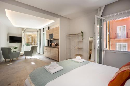 1 dormitorio con 1 cama grande y 2 toallas en Diana Suites 23, en Málaga