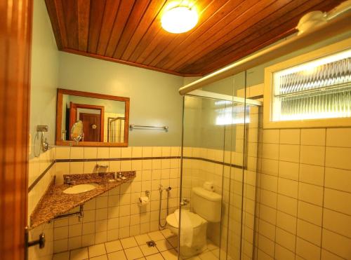 a bathroom with a toilet and a sink and a mirror at Ecoporan Hotel Charme Spa & Eventos in Itacaré